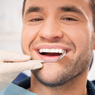Handsome smiling man at doing checkup at dentist's surgery